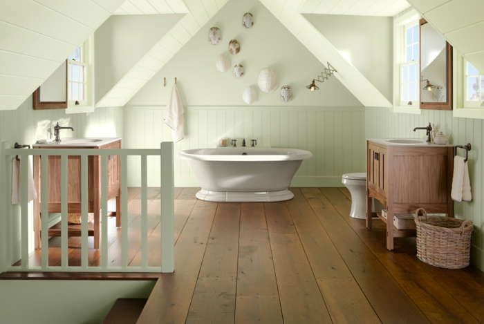lambris mural vert pâle, baignoire blanche, plancher en bois, panier tressé