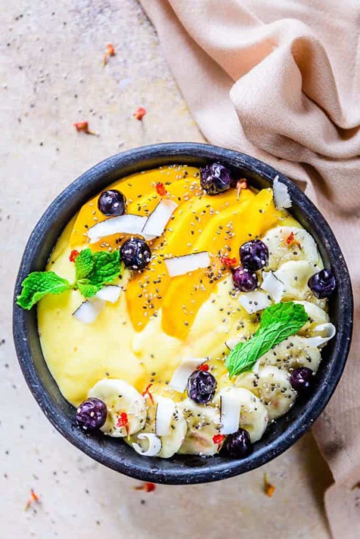 smoothie bowl recette saine et délicieuse aux saveurs tropicales, smoothie bowl santé à la mangue, banane, yaourt et lait de coco 