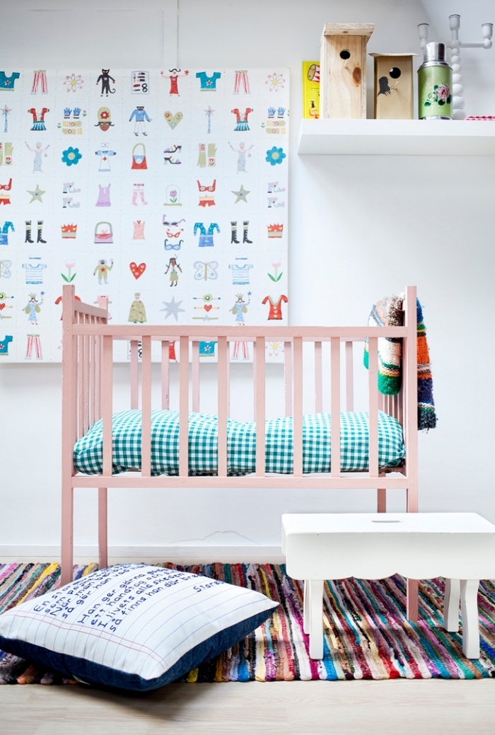 modèle de lit bebe fille à barreaux de bois avec couverture de lit à motifs carreaux vert et blanc, modèle de tapis coloré ethnique