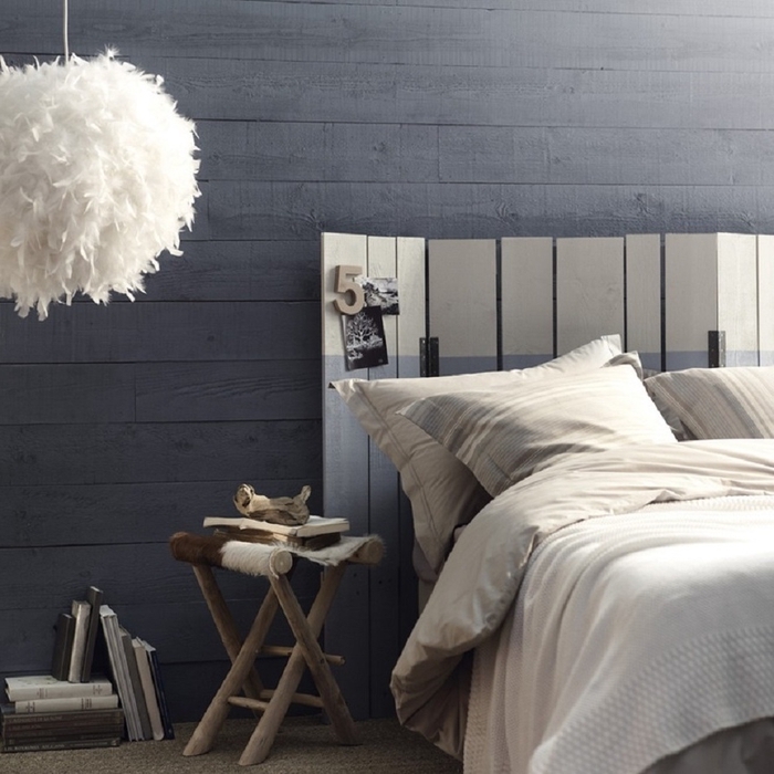 chambre à coucher de style rustique revêtue de lambris gris anthracite avec une tete de lit en palette peinte en blanc et gris