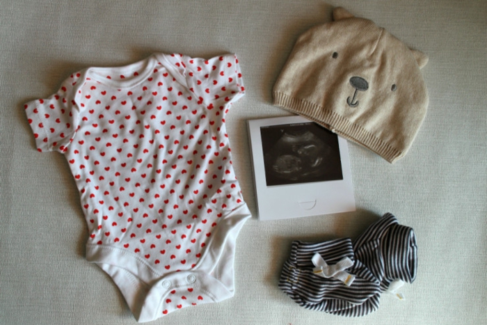 petites chaussettes, un body, chapeau et photo ultrasound, surprise préparée pour annoncer la bonne nouvelle