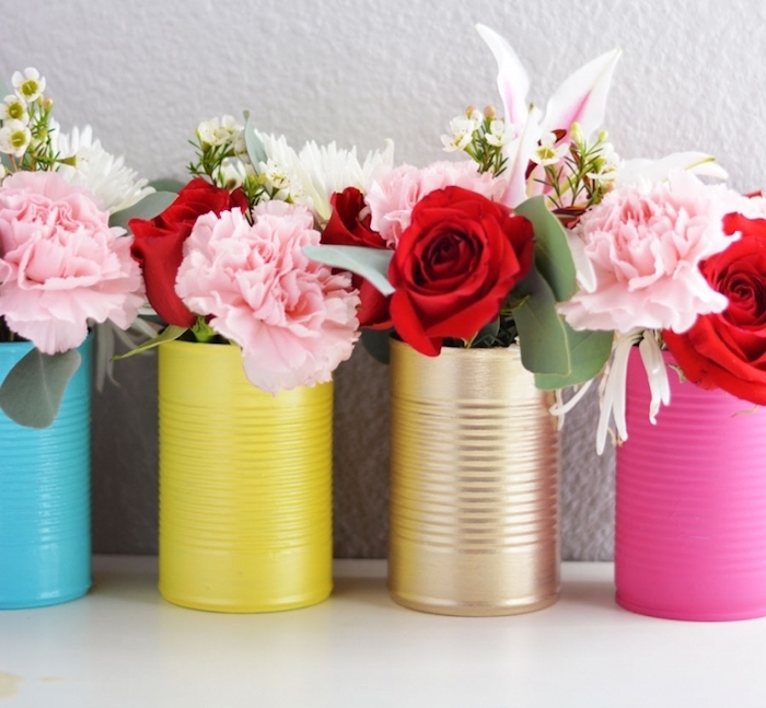 exemple d activité manuelle pour ado, des boites de conserve décorées de peinture jaune rose, or et bleu avec des bouquets de fleurs à l intérieur