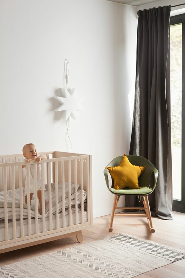 décoration chambre bébé fille, lit rose, fauteuil en vert réséda, une grande étoile blanche au mur, tapis en rose pastel et en gris, rideaux gris perle