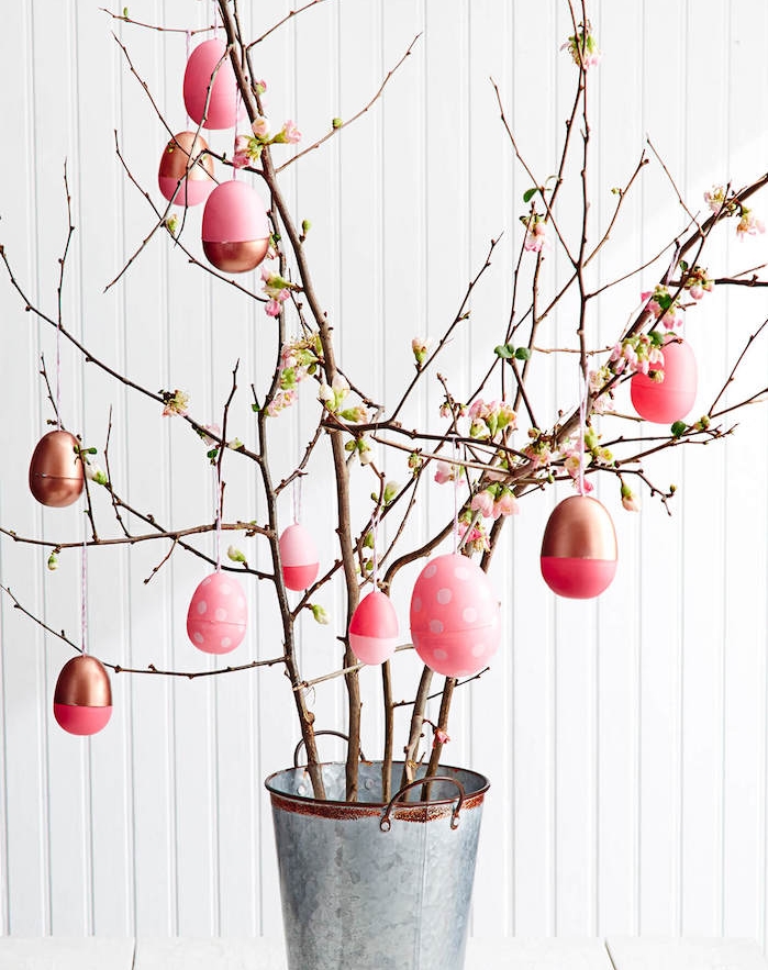 arbre de paques en branches fleuries avec des oeufs rose et or dans un seau, deco paques original pour votre interieur maison 