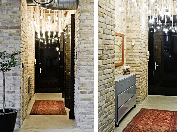 deco couloir aux murs en pierre et tuyaux apparents, éclairage moderne avec cordes et ampoules électrique à différentes longueurs