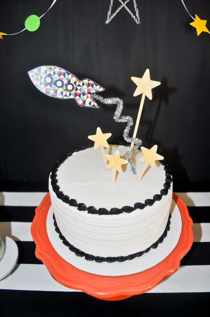 gateau anniversaire facile à préparer au glaçage blanc et noir sur les bords décoré avec des cake-toppers à thème espace