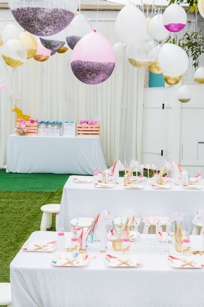 un anniversaire theme licorne en rose, blanc et doré avec une décoration en toute légèreté de ballons personnalisés avec des paillettes 