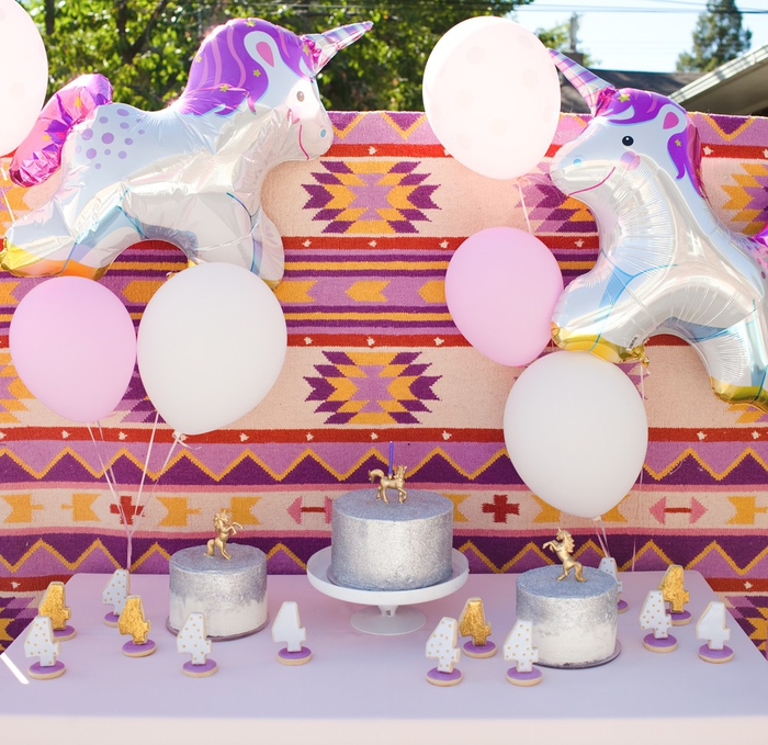 idée pour une jolie déco de buffet d anniversaire licorne en plein air avec des ballons géants aluminium et des motifs aztèques colorés en toile de fond