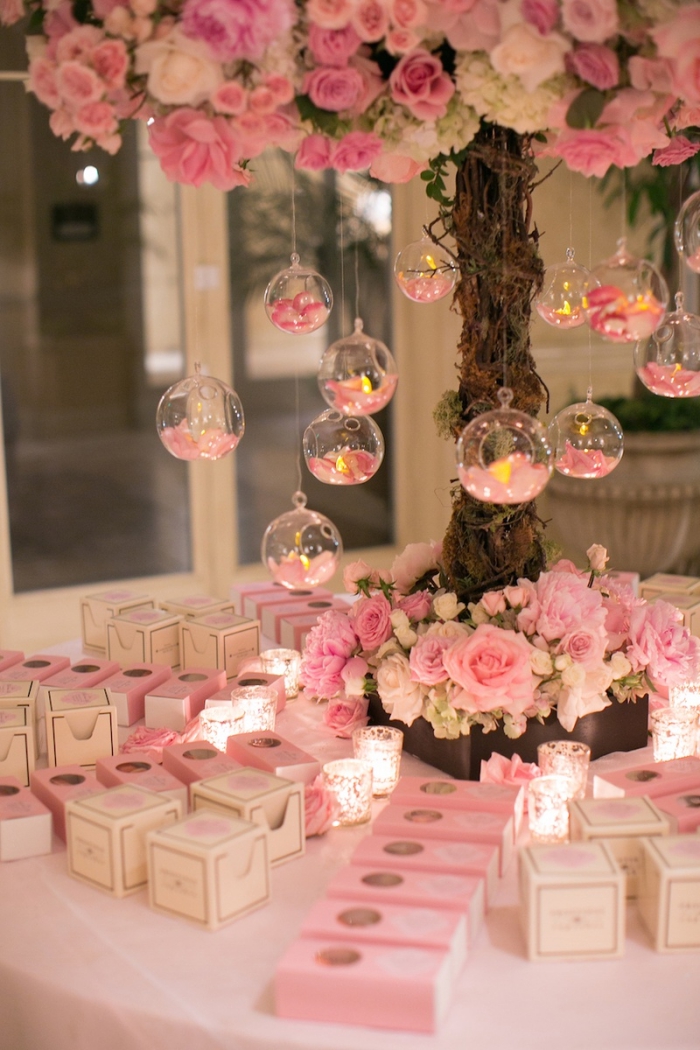 decoration mariage romantique en rose et blanche avec bougies et roses, produits cosmétiques pour les invités