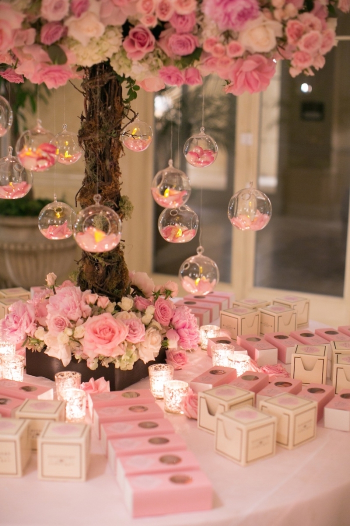 decoration mariage romantique en rose et blanche avec bougies et roses, produits cosmétiques pour les invités