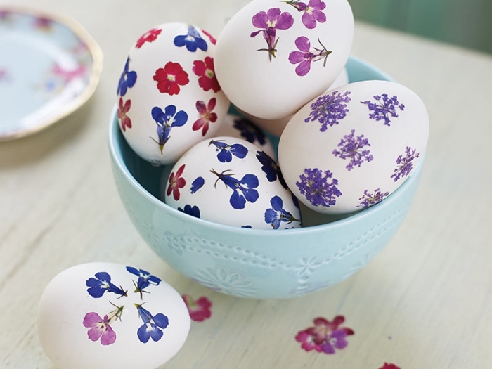 idée pour decoration paques facile sur coquilles blanches avec stickers autocollants à design floral en violet bleu et rouge