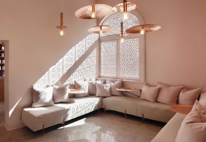 idée aménagement d'un salon avec canapé d'angles et coussins rose pastel, exemple peinture rose poudré dans le salon