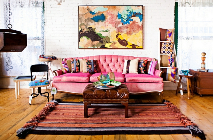 tapis rétro style ethnique, canapé rose capitonné, peinture abstraite, coussins en couleurs agréables