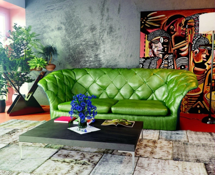 déco murale béton ciré, panneau mural bariolé en teintes rayonnantes, canapé vert, tapis patchwork, table basse moderne