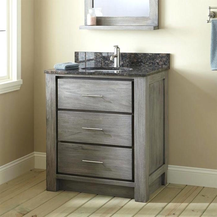petit meuble de lavabo gris pour salle de bain avec murs et sol beige