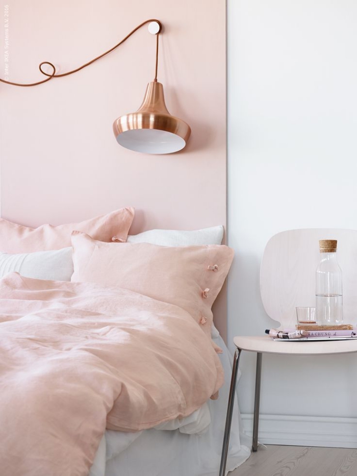aménagement chambre fille aux murs blancs avec pan de couleur rose poudré, lit bas avec lampe industriel à design cuivré