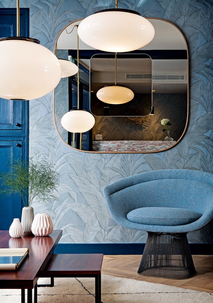 salon aux murs habillés en papier peint moderne de couleur bleu clair, déco de salon au plancher de bois et meubles bleus