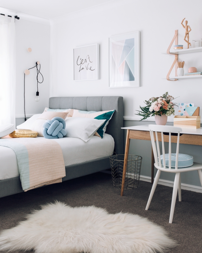 amenagement chambre à coucher moderne au design scandinave épuré en tons pastel avec un coin bureau près du lit et un coussin à noeud tendance