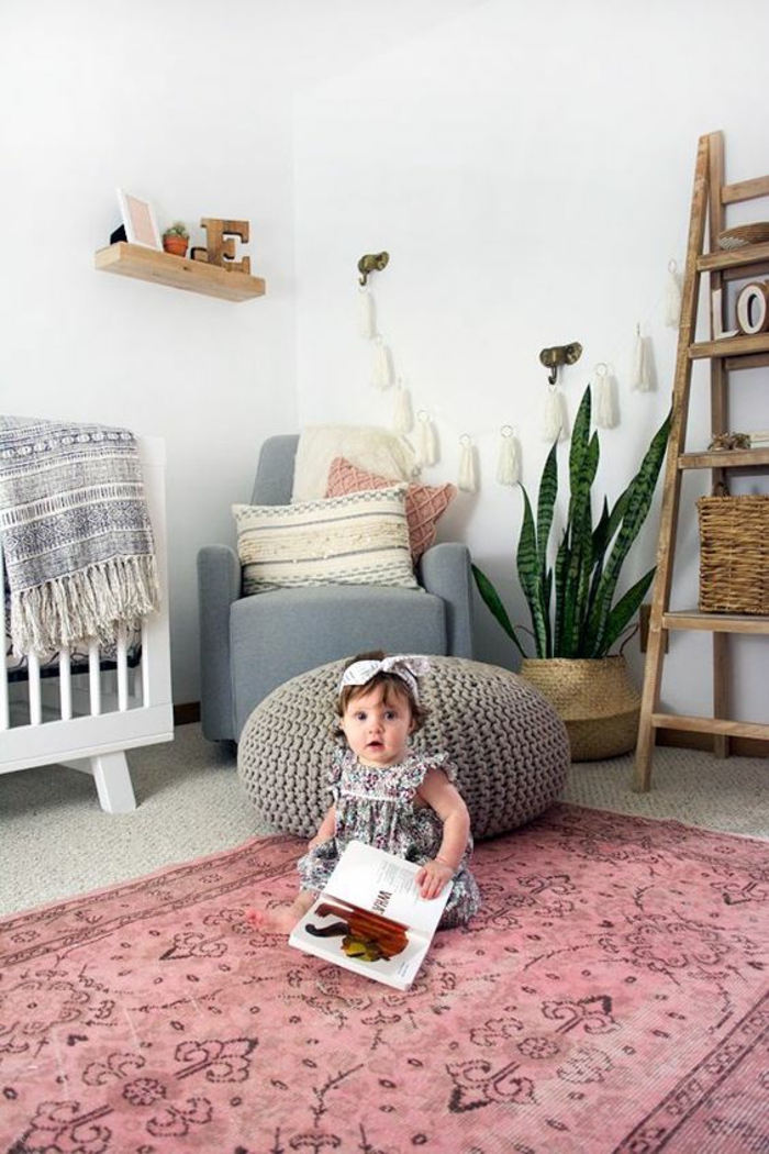 chambre gris et blanc avec un tapis rose aux ornements en noir, échelle avec des casiers et avec le nom de l'enfant
