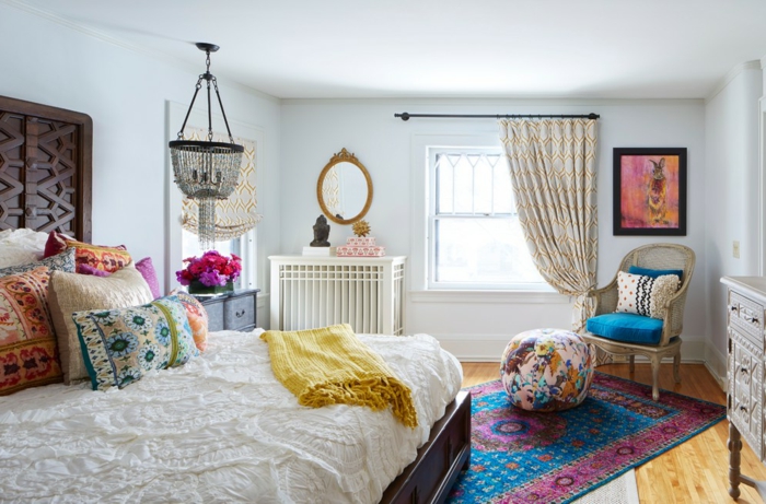 tapis vintage en bleu et rose, lit avec plusieurs coussins, plafonnier oriental, pouf en couleurs joyeuses