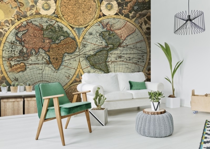 revêtement mural dans le salon avec un papier peint vintage à design globe du monde et boussoles, déco en blanc et bois avec accessoires verts