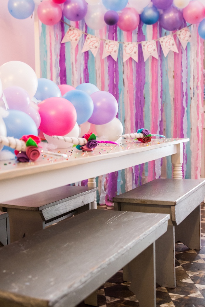 idées déco pour un anniversaire licorne, un chemin de table original en ballons aux couleurs du rideau à franges 