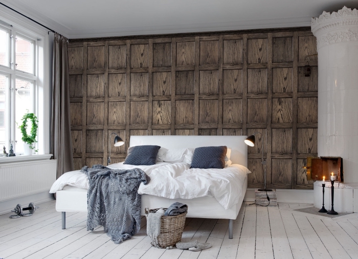 aménagement de chambre à coucher blanc et bois avec revêtement mural en papier peint imitation bois et cheminée blanche