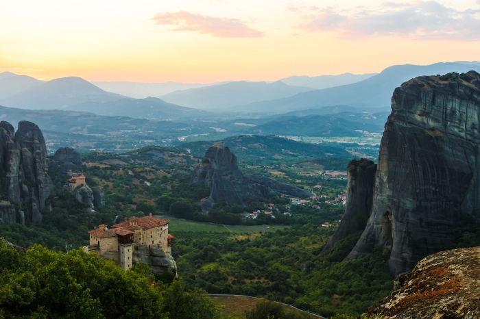 photo de site touristique les Météores en Grèce, vue d'en haut vers les montagnes lointaines et le village au lever du soleil