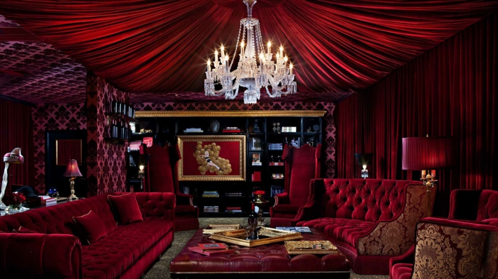 un séjour de luxe en couleu lie de vin, plafonnier cristal, sofas burgundi, rideaux