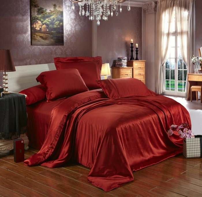 sol en planches de bois, linge de lit rouge, chandelier en cristal, fenetre romantique