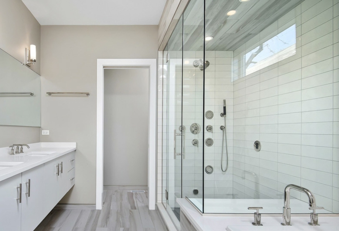 douche avec vitrage qui suit les lignes de la niche, meuble suspendu en blanc, deux lavabos en forme carrée, miroir sur toute a longueur du mur