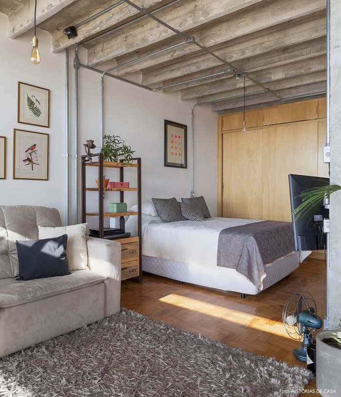 aménagement d'une chambre a coucher moderne d'esprit atelier avec un coin de repos équipé d'un canapé