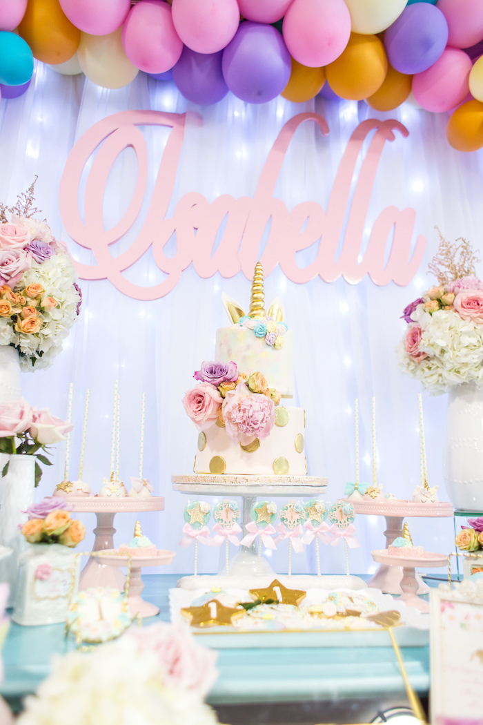 une décoration d'anniversaire theme licorne féerique et poétique en tons pastel, fleurs et objets licorne personnalisés 