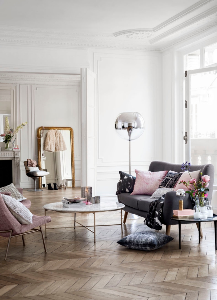 idée déco de salon aux murs blancs avec canapé gris et fauteuil de couleur rose poudré, modèle de miroir doré