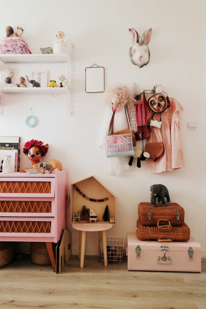 chambre rose et gris, meuble en rose et marron, valise de rangement rose et deux valses plus petites en marron, parquet beige 