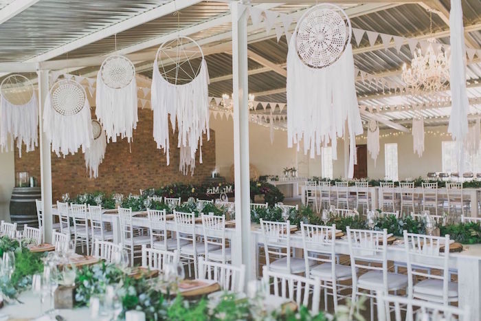deco mariage style boheme chic, avec des attrape reve geant en dentelle suspendu, chaises blanches, décoration végétation verte