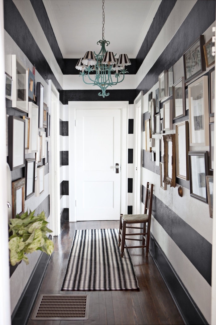 peinture couloir rayée en blanc et noir avec une décoration art de cadres photos à différentes tailles et couleurs