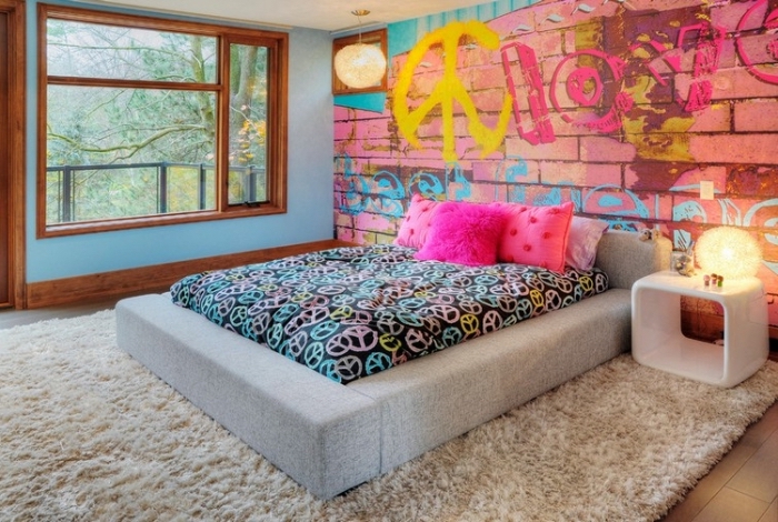 modèle de papier peint chambre ado à design graffiti rose et bleu, aménagement pièce intime avec grand lit et meuble blanc