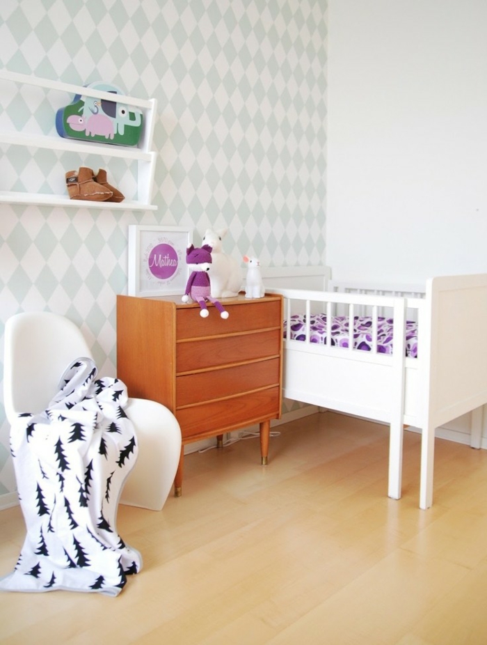 mur en blanc et bleu pastel, lit bébé fillette en rose, meuble en bois clair, étagères blanches, parquet stratifié en beige-jaune 