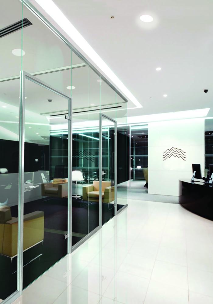 espace carré avec des meubles d'office, decoupe verre, carrelage noir dans l'espace séparé et carrelage blanc brillant dans l'espace commun