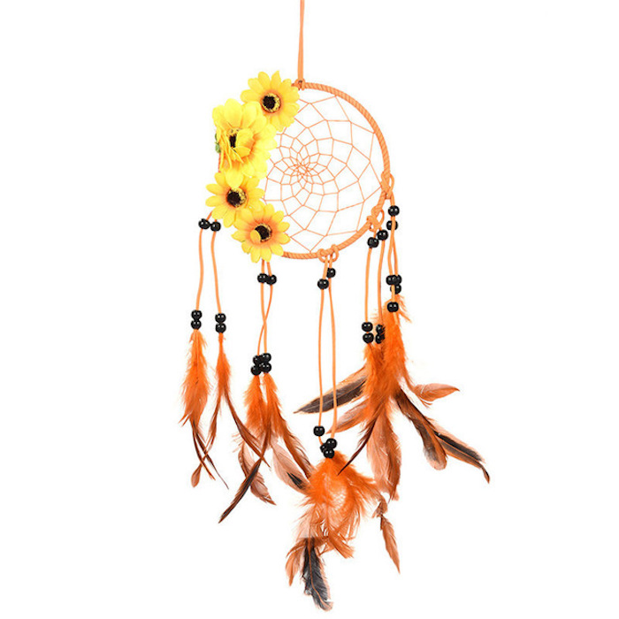 petit capteur de rêve orange avec décoration de perles noires, plumes marron et orange et des fleurs jaunes tourne sol