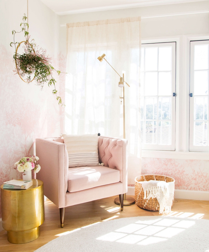 coin de lecture dans une chambre rose avec grande fenêtre, aménagement pièce avec fauteuil rose et table dorée
