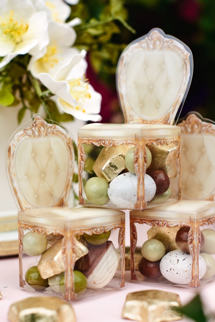 sucreries et bonbons arrangés dans une boîte originale en forme de chaise baroque beige à dos boutonné