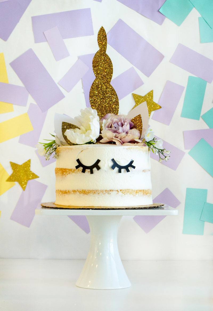 gateau-licorne-personnalisé-naked-cake-décoration-de-gâteau-anniversaire-florale-cake-topper-corne joli gateau licorne façon naked cake décoré avec des accessoires licorne et un mur de confettis en arrière-plan