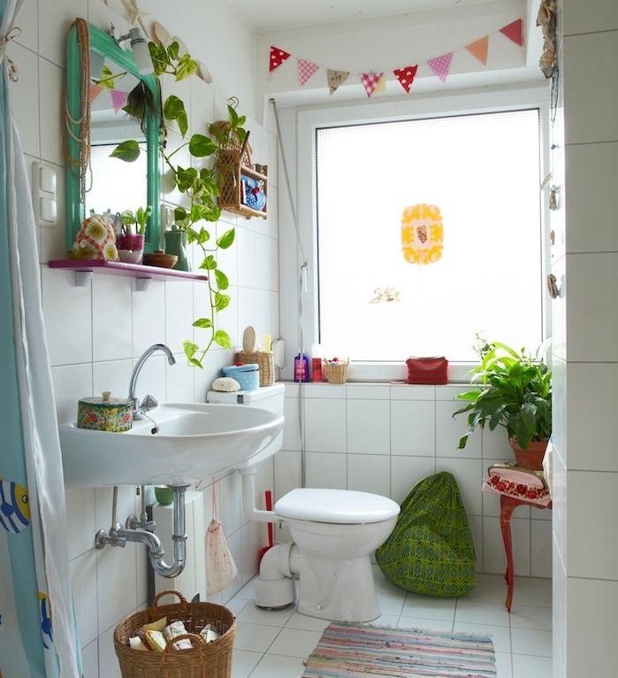 decoration petite salle de bain avec carrelage retro blanc, lavabo et wc blanc, guirlande decorative, plantes et accessoires colorés