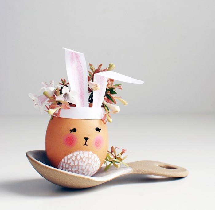 activité de paques avec une coquille d oeuf petit vase de fleur ,motif lapin de paques avec oreilles en papier et bouquet de fleurs à l intérieur