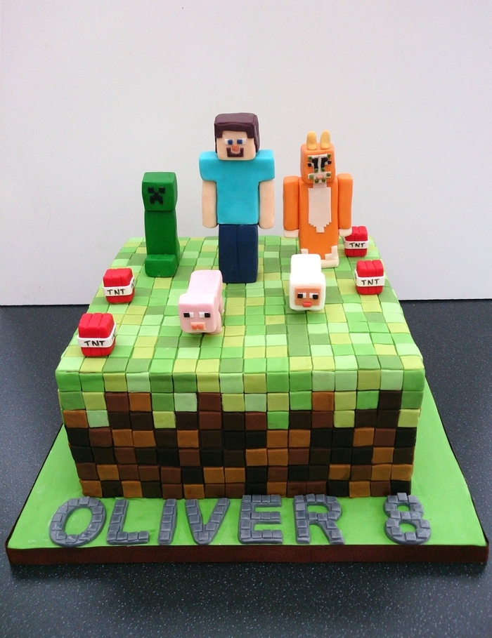 joli gateau d'anniversaire personnalisé sur le thème minecraft recouvert de tas de pixels en pâte à sucre