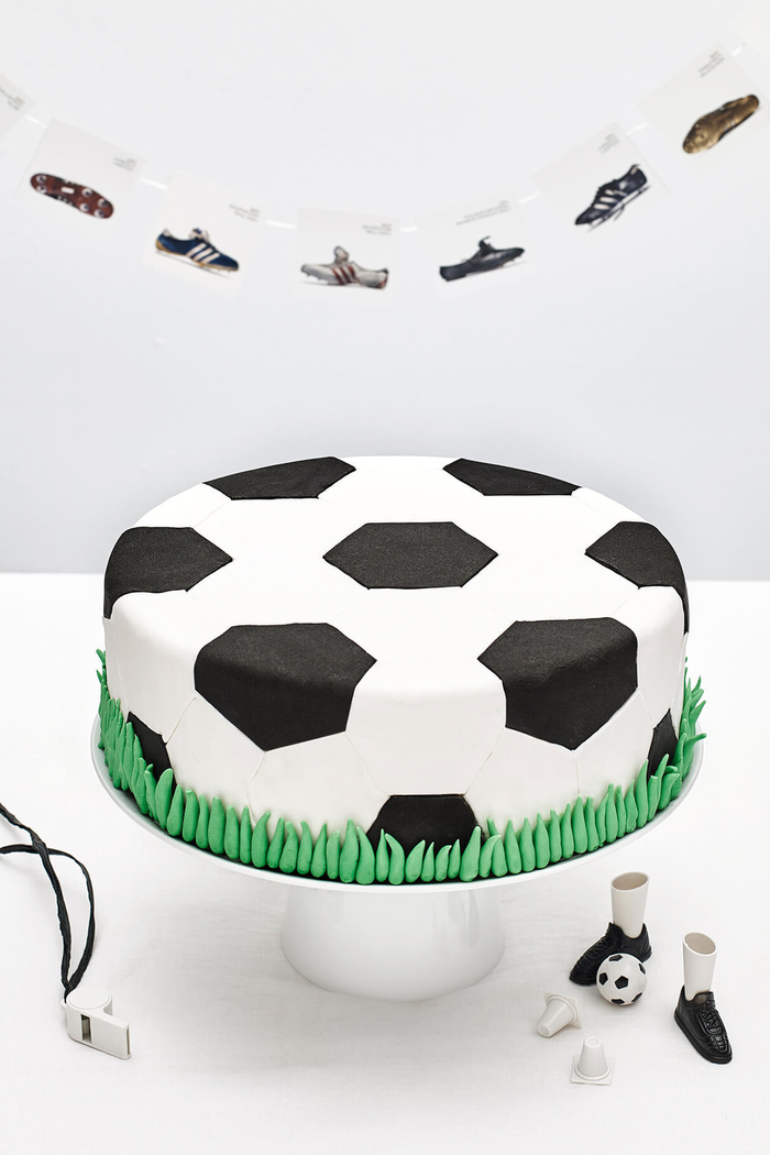 joli gâteau d'anniversaire garçon recouvert de pâte à sucré façon ballon de foot aux bords pelouse en pâte à sucre