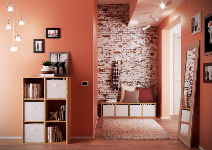 deco hall entrée aux murs oranges avec pan de briques rouges et blanches, modèle de suspension lumineuse avec cordes et ampoules en verre