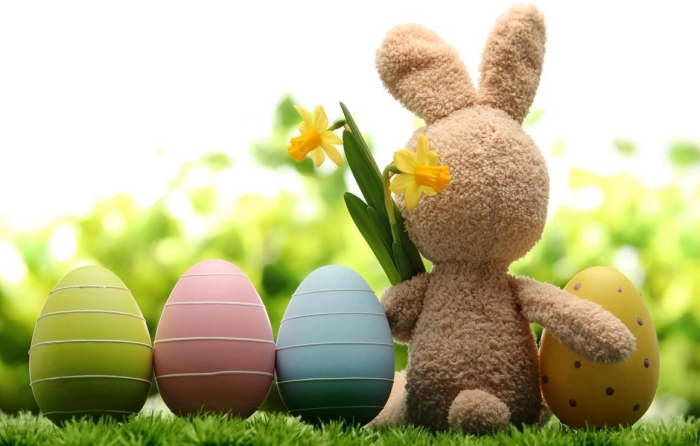 décoration mignonne pour la fête des paques avec un lapin en peluche et oeufs en plastique colorés en nuances pastel